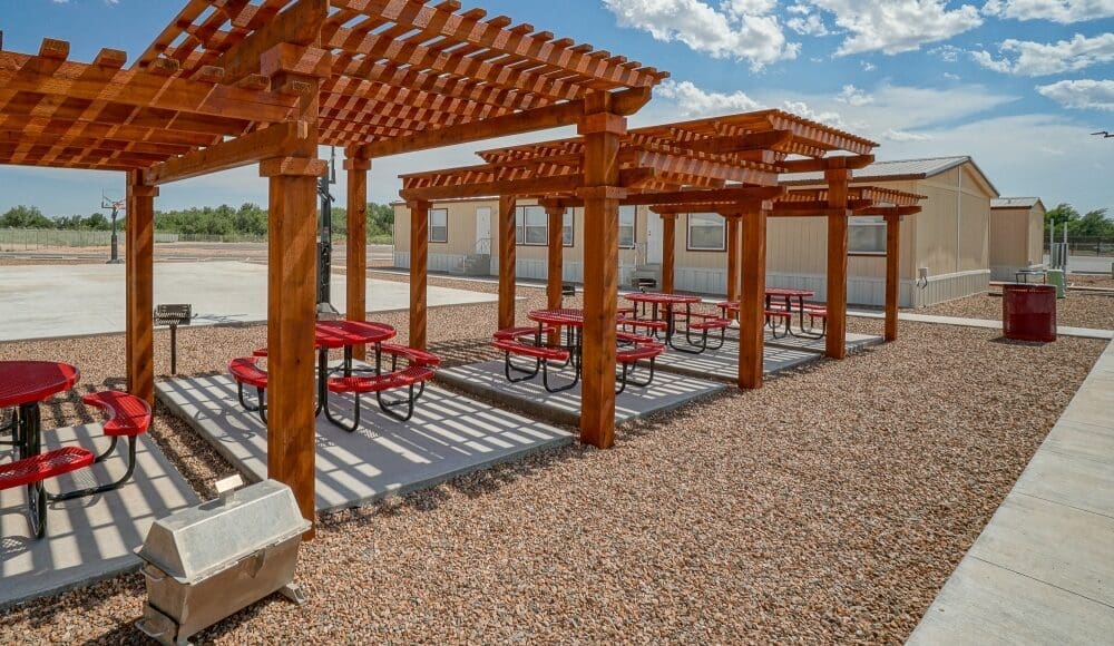 Pergolas in CHH Jal lodge with sitting areas arranged on round tables by the basketball courtyard