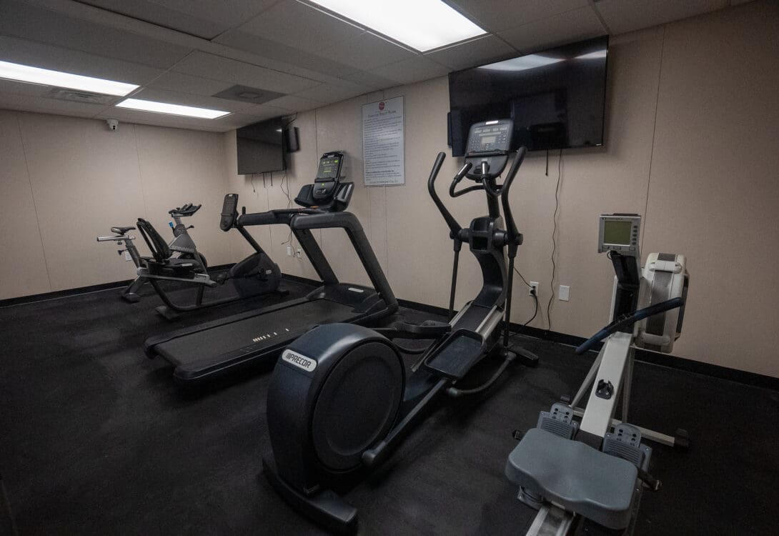 Workout room in CHH Pecos with several treadmills and two flat screen TVs mounted in the wall