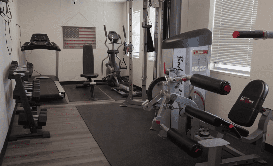 A workout room in CHH Loving Lodge with a treadmill and weight lifting equipment