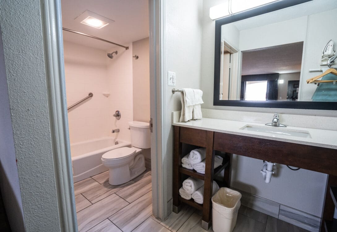 The inside of private bathroom in a CHH Big Spring unit with a lavatory, separate from the water closet and shower area with a bath tub