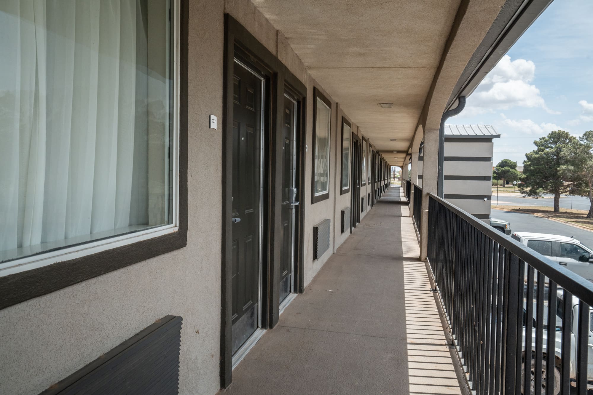 A long shot of the hallway in front of the room units in CHH Big Spring location facing outside the parking lot